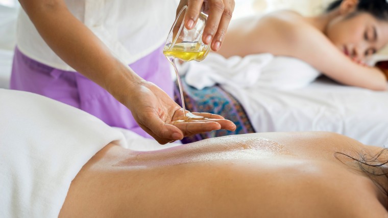 Two women getting massages with hemp massage oil.