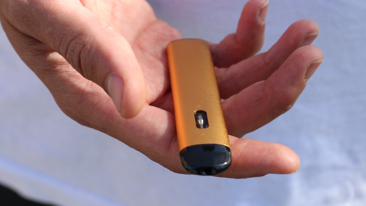 A disposable CBD pen in someone's hand.